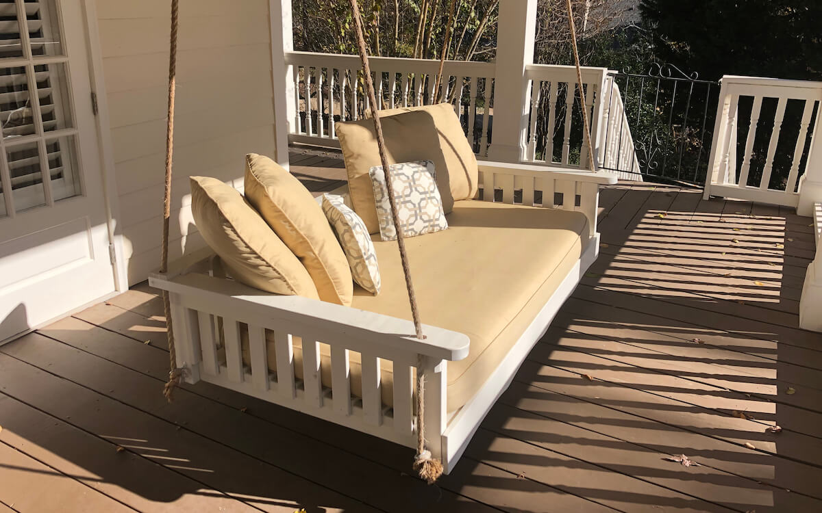 Wooden swing hanging on a front porch